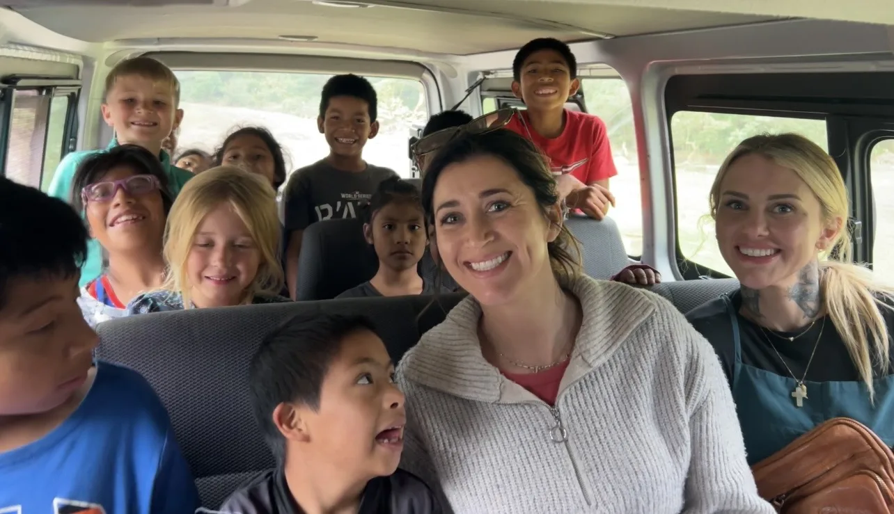A van full of smiling Guatemalan children and team members on the way to serve